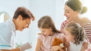 Imagen de una familia feliz haciendo vacunar sus niños